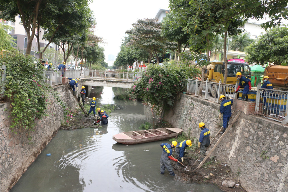 Công nhân Công ty trách nhiệm hữu hạn một thành viên Thoát nước Hà Nội thực hiện nạo vét bùn trên mương trong những ngày giá rét. (Ảnh: TTXVN phát)