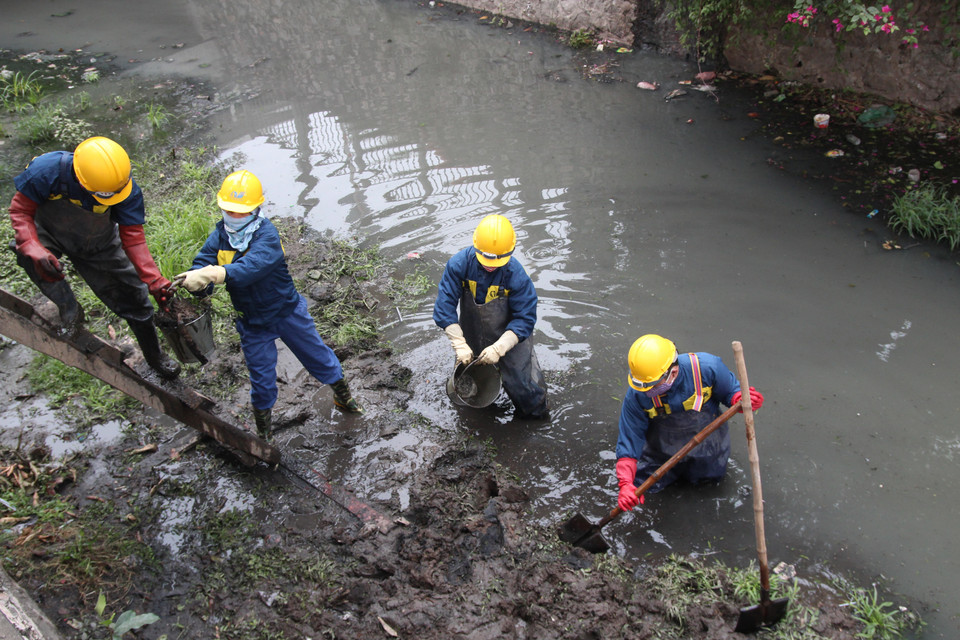 Công ty TNHHMTV Thoát nước Hà Nội thực hiện nhiệm vụ chuyên môn trong những ngày nhiệt độ xuống thấp. (Ảnh: TTXVN phát)