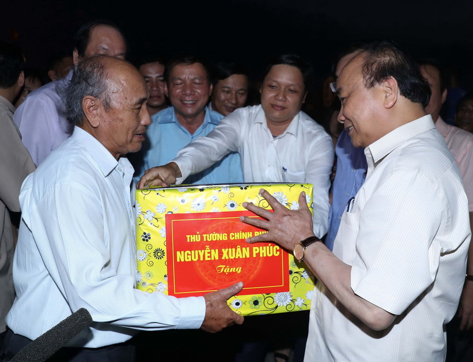 Thủ tướng Nguyễn Xuân Phúc thăm Cảng cá Cửa Việt và tặng quà cho ngư dân. (Ảnh: Thống Nhất/TTXVN)