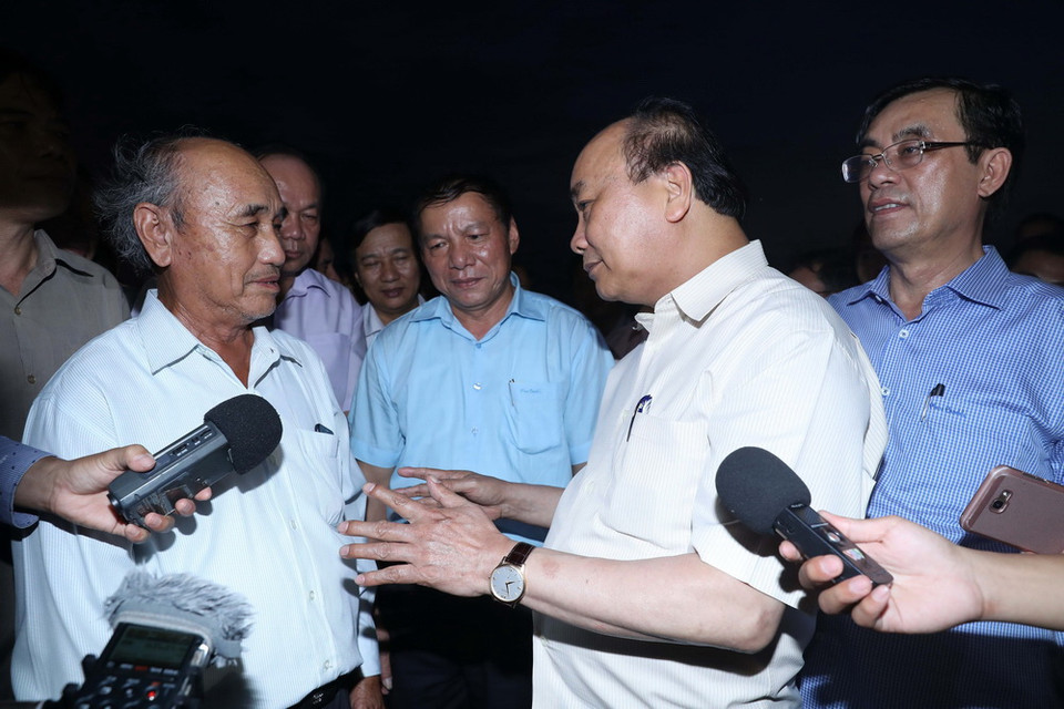 Thủ tướng Nguyễn Xuân Phúc thăm hỏi ngư dân tại Cảng cá Cửa Việt. (Ảnh: Thống Nhất/TTXVN)