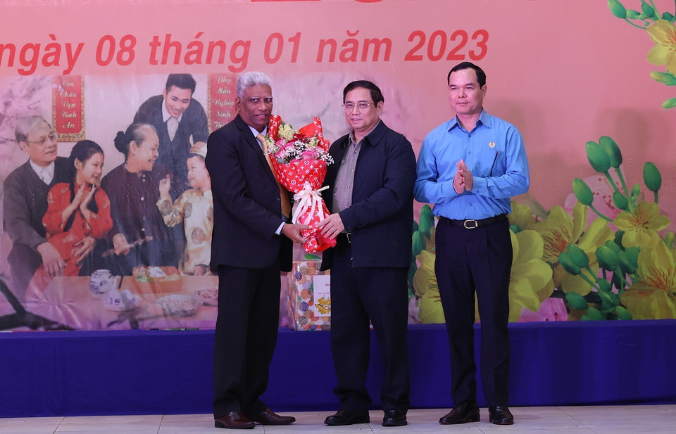 Thủ tướng Phạm Minh Chính tặng hoa cho doanh nghiệp có nhiều đóng góp trong việc chăm lo đời sống công nhân, người lao động. (Ảnh: Dương Giang/TTXVN)