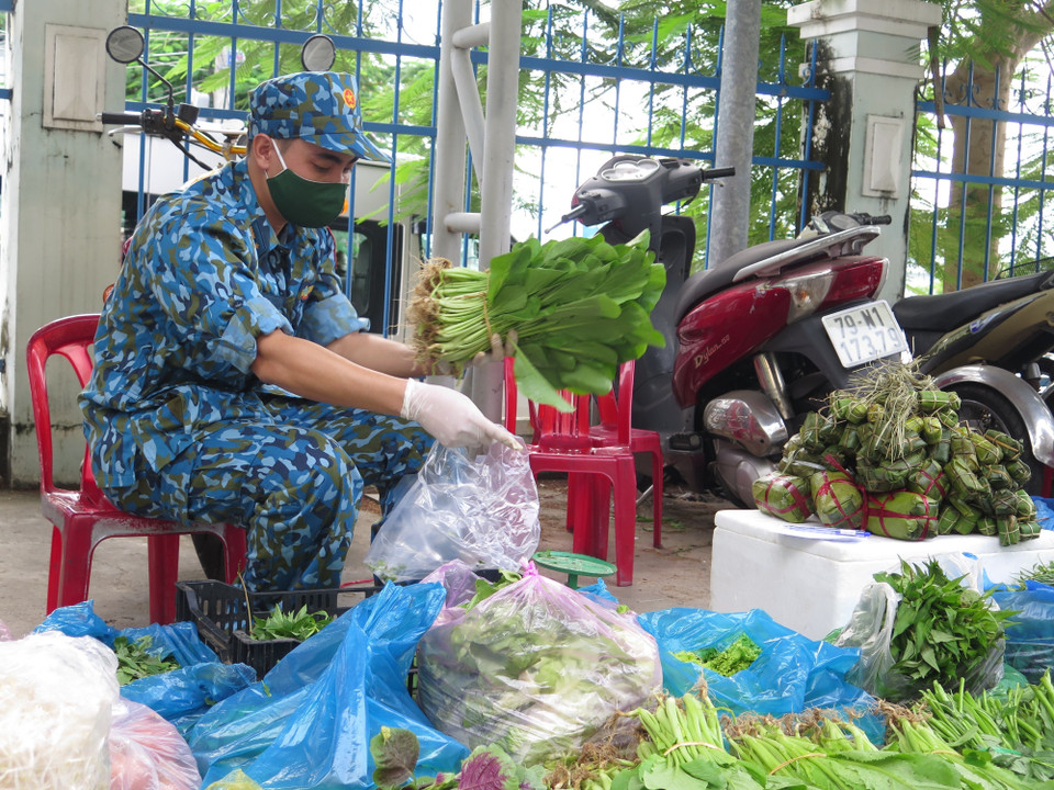 Cán bộ học viên Trường Sỹ quan thông tin phân loại rau xanh thành các đơn hàng cung ứng cho người dân xã Vĩnh Thọ, thành phố nơi Nha Trang. (Ảnh: Phan Sáu/TTXVN)