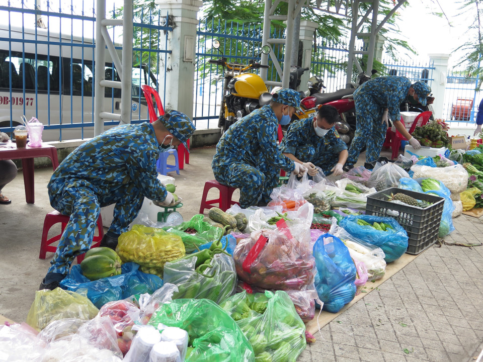 Cán bộ học viên Trường Sỹ quan thông tin phân loại thực phẩm thành các đơn hàng cung ứng cho người dân xã Vĩnh Thọ, thành phố nơi Nha Trang. (Ảnh: Phan Sáu/TTXVN)