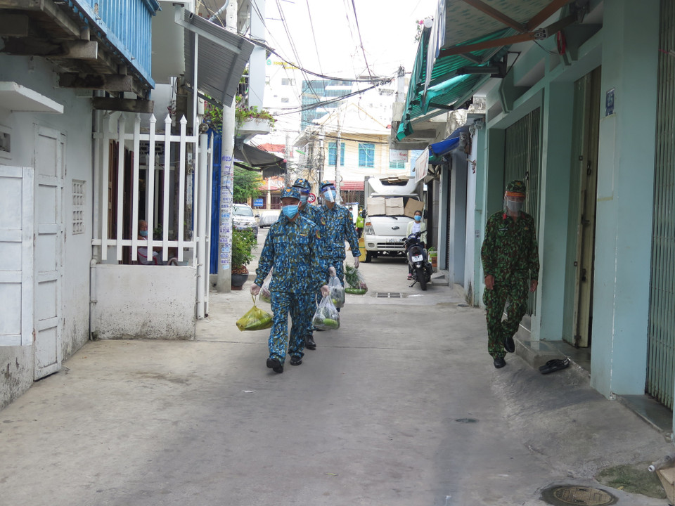 Cán bộ, chiến sỹ Trường Sỹ quan thông tin vận chuyển lương thực thực phẩm cho người dân trong các khu vực bị phong tỏa.(Ảnh: Phan Sáu/TTXVN)