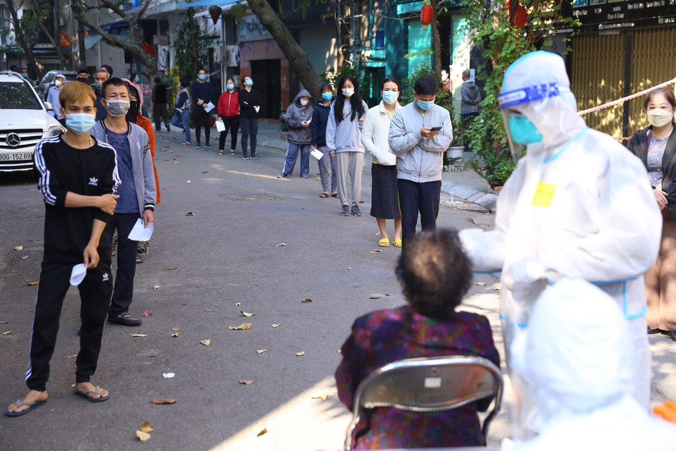 Người dân trong khu vực bị phong tỏa phố Đỗ Hành được lấy mẫu xét nghiệm sàng lọc COVID-19. (Ảnh: Hoàng Hiếu/TTXVN)