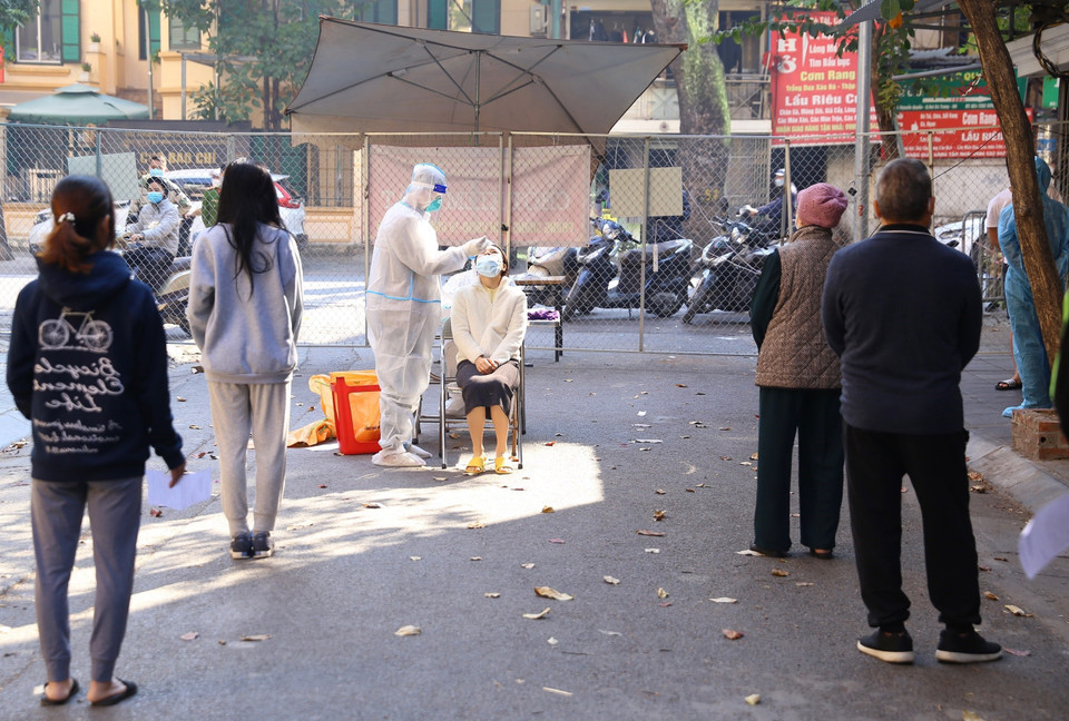 Người dân trong khu vực bị phong tỏa phố Đỗ Hành được lấy mẫu xét nghiệm sàng lọc COVID-19 sáng 4/12. (Ảnh: Hoàng Hiếu/TTXVN)