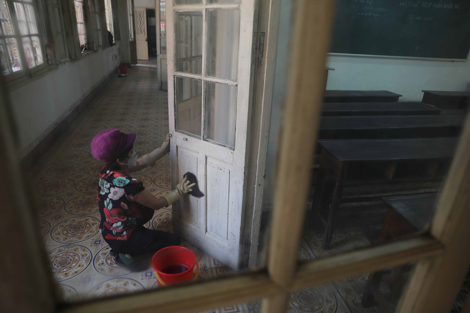 Trường THPT Trần Phú, quận Hoàn Kiếm khẩn trương vệ sinh, khử khuẩn phòng học, bàn ghế... để đón học sinh đi học trực tiếp vào ngày 6/12 tới. (Ảnh: Thanh Tùng/TTXVN)