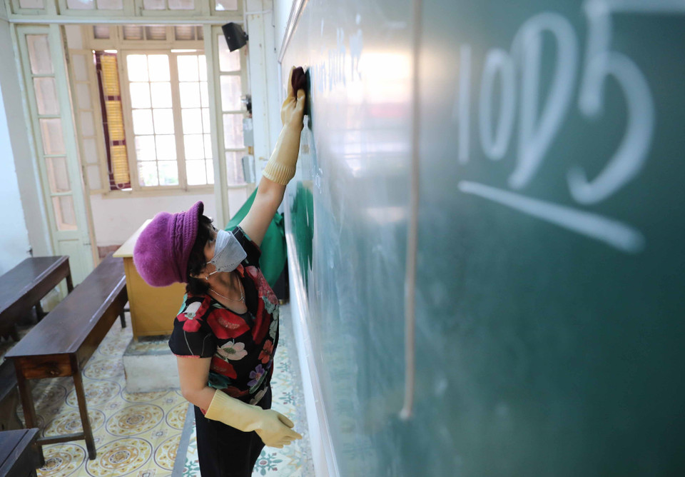 Vệ sinh, khử khuẩn phòng học, bàn ghế tại Trường THPT Trần Phú, quận Hoàn Kiếm. (Ảnh: Thanh Tùng/TTXVN)