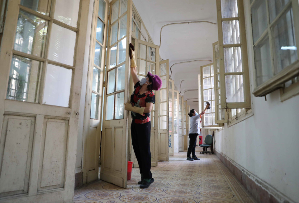 Trường Trung học phổ thông Trần Phú, quận Hoàn Kiếm khẩn trương vệ sinh, khử khuẩn phòng học, bàn ghế... để đón học sinh đi học trực tiếp vào ngày 6/12. (Ảnh: Thanh Tùng/TTXVN)