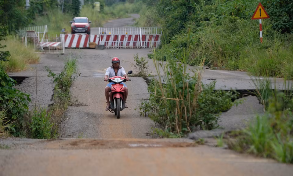 Bất chấp cảnh báo, người dân địa phương vẫn lưu thông qua tuyến đường tránh phía Nam thành phố Bảo Lộc đã cấm lưu thông. (Ảnh: Nguyễn Dũng/TTXVN)