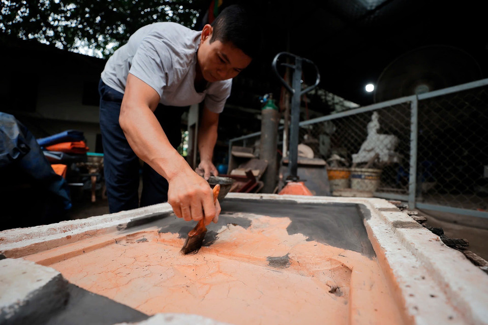 Người thợ tỉ mỉ từ khâu làm khuôn cho sản phẩm. (Ảnh: Minh Quyết/TTXVN)