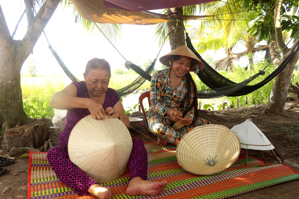 Người trẻ kế tiếp nghề chằm nón lá tại thị trấn Thới Lai (Cần Thơ). (Ảnh: Thu Hiền/TTXVN)