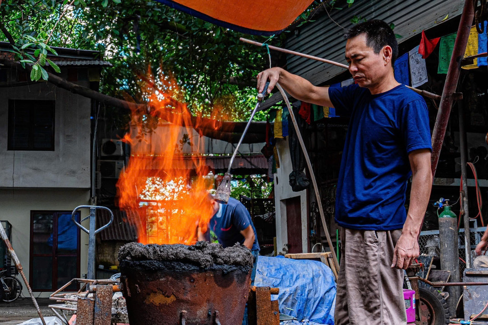 Người thợ chuẩn bị lò để nấu chảy đồng nguyên chất trước khi đúc. (Ảnh: Phạm Tuấn Anh/TTXVN)