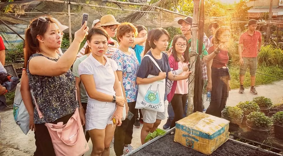 Du khách thăm quan và trải nghiệm các quy trình ươm cây giống. (Ảnh: M.Mai/Vietnam+)