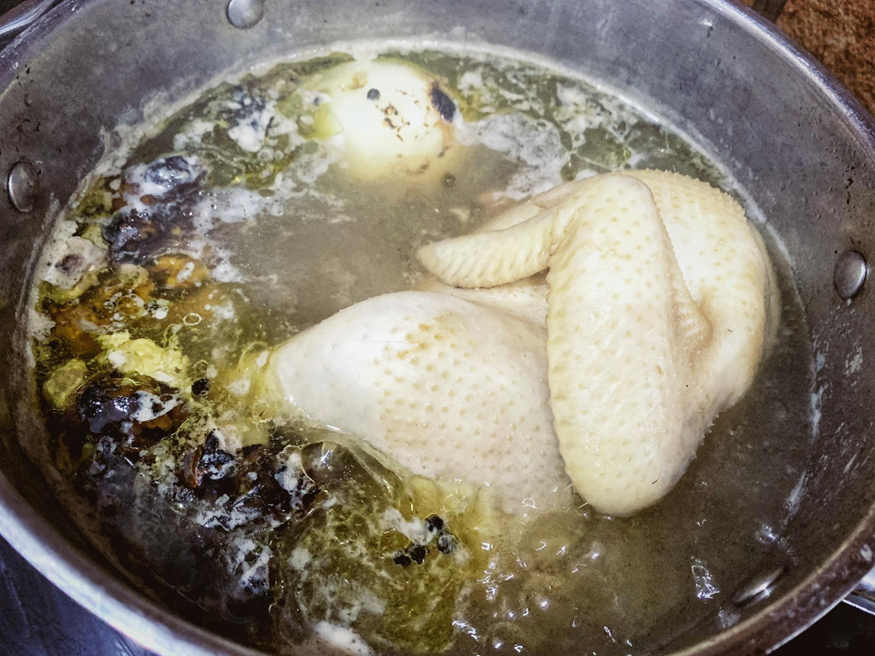 Luộc gà cùng các loại thảo mộc và hỗn hợp gia vị giúp gà có hương vị thơm ngon. (Ảnh: Mai Mai/Vietnnam+)