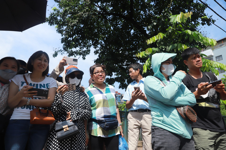 Trời nắng cũng như trời mưa, nhiều bậc phụ huynh vẫn đứng chờ con trong suốt thời gian làm bài thi. (Ảnh: PV/Vietnam+)