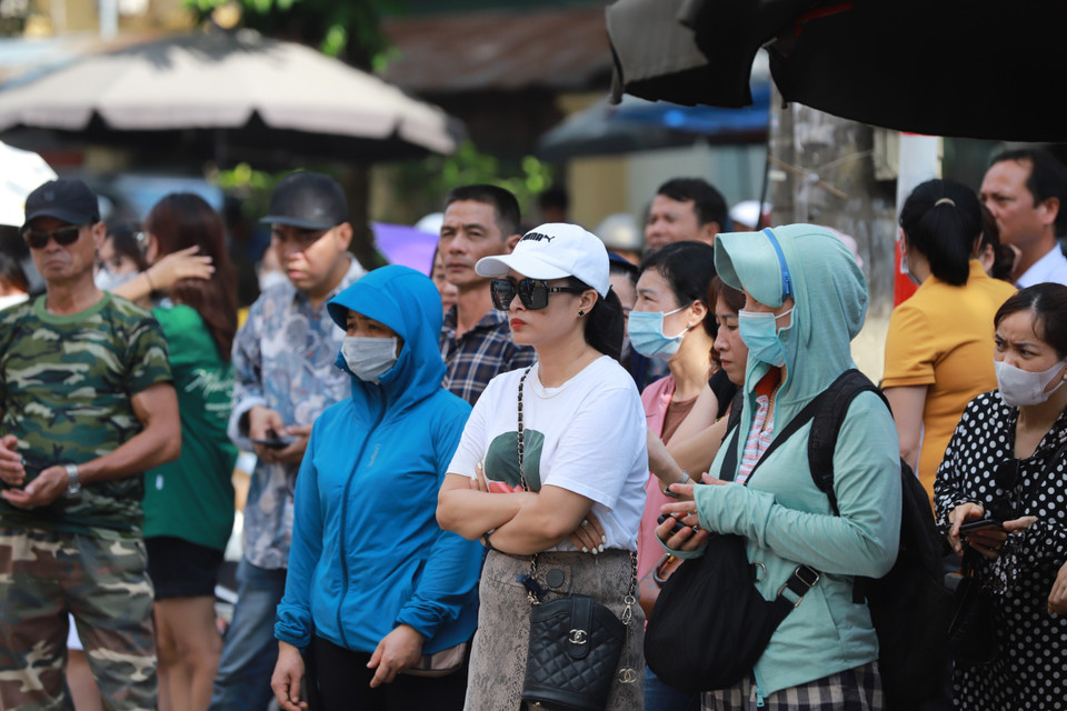 Dù kỳ thi diễn ra vào ngày trong tuần nhưng nhiều bậc phụ huynh vẫn 'túc trực' ngay trước cổng trường tại điểm thi mà con em mình dự thi. (Ảnh: PV/Vietnam+)