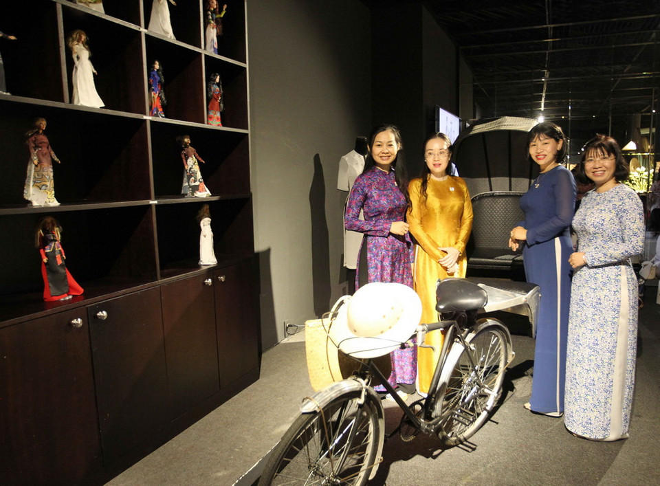 Các em học sinh xem các mẫu áo dài tại triển lãm 'Duyên dáng Áo dài Thành phố Hồ Chí Minh.' (Ảnh: Quang Nhựt/TTXVN)