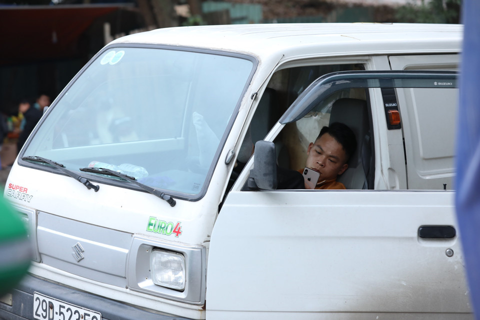 Nhiều lái xe chờ đợi, ăn, ngủ tại xe trước Trạm đăng kiểm 29-32D. (Ảnh: Hoàng Hiếu/TTXVN)