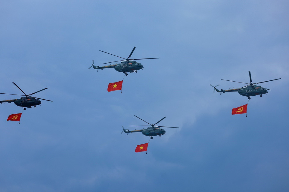 Máy bay trực thăng mang cờ Đảng, cờ Tổ quốc bay qua Lễ đài. (Ảnh: Dương Giang/TTXVN)