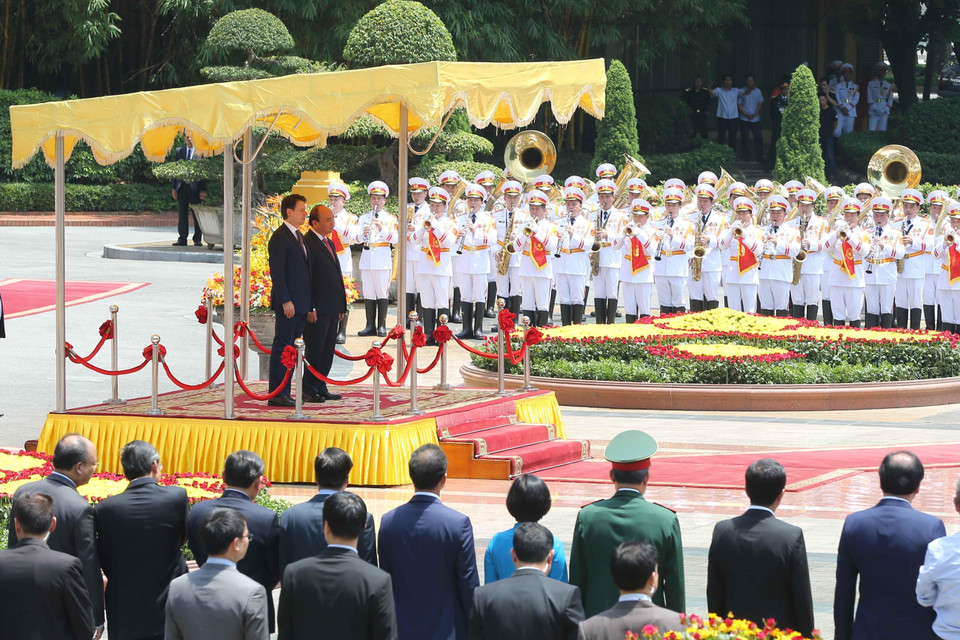 Thủ tướng Nguyễn Xuân Phúc và Thủ tướng Italy Giuseppe Conte trên bục nghe quân nhạc cử quốc thiều hai nước. (Ảnh: Doãn Tấn/TTXVN)