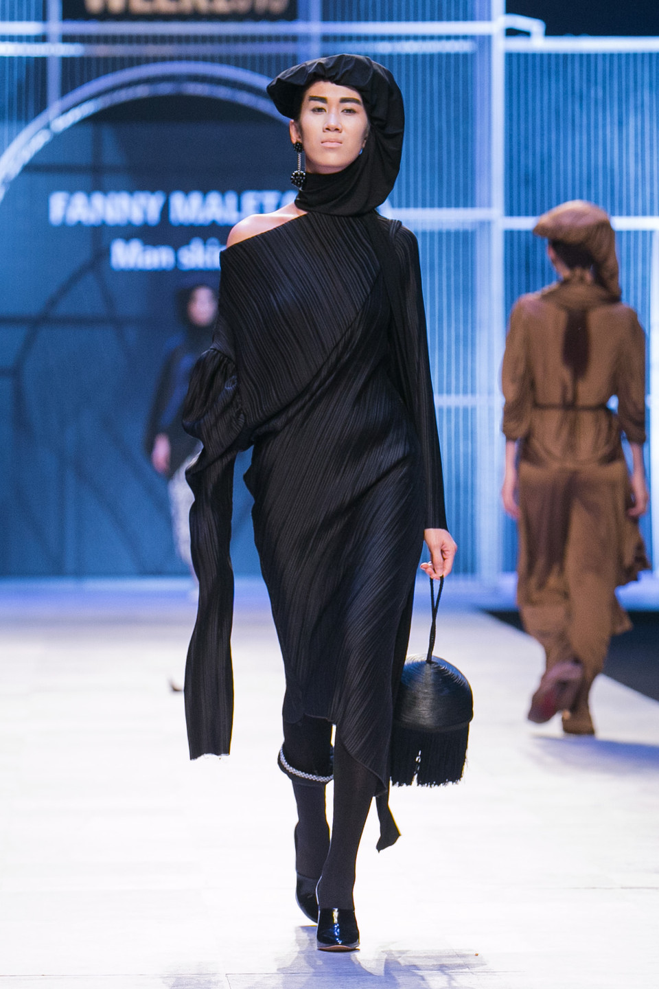 ...còn mẫu nữ 'nhảy tưng tưng' trong chiếc đầm đen bó sát đến tận gót chân. (Ảnh: BTC)