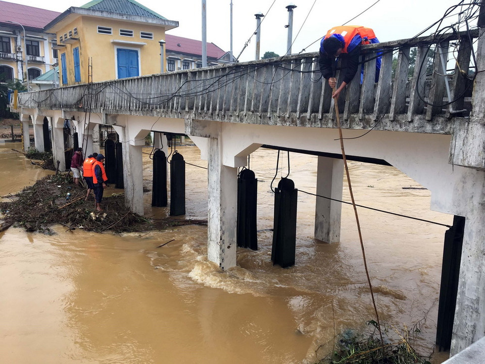 Lực lượng chức năng dọn rác khơi thông dòng chảy, bảo vệ cho cầu Ga (thành phố Huế). (Ảnh: Quốc Việt/TTXVN)
