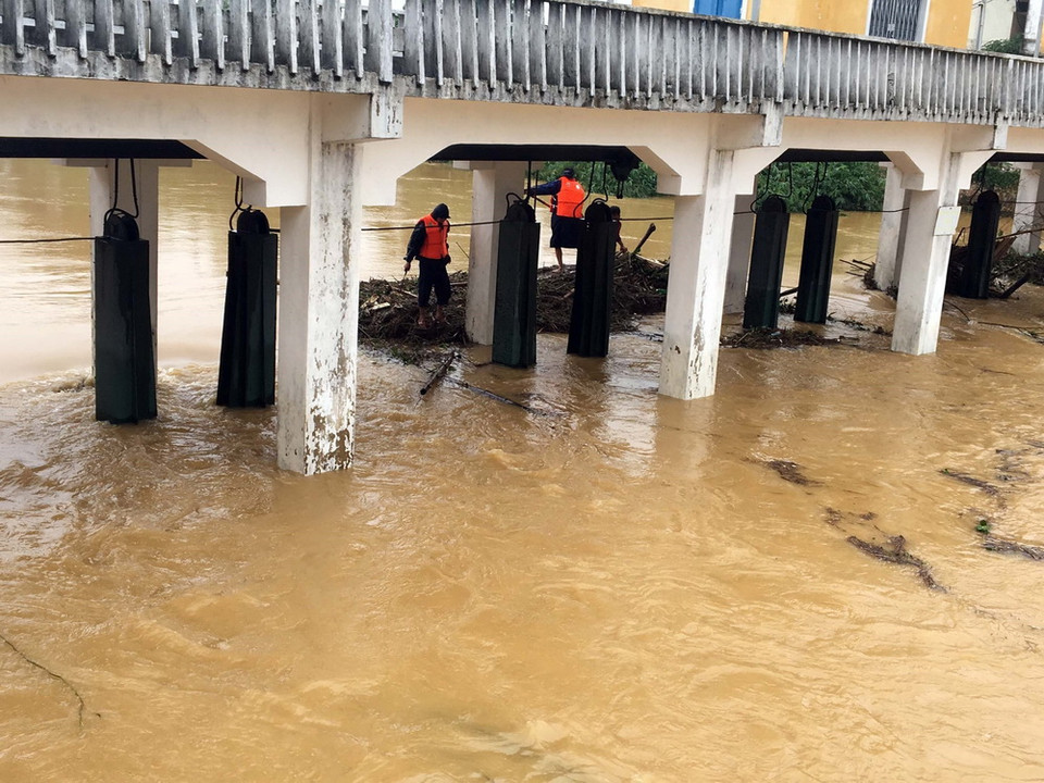 Lực lượng chức năng dọn rác khơi thông dòng chảy, bảo vệ cho cầu Ga (Huế). (Ảnh: Quốc Việt/TTXVN)