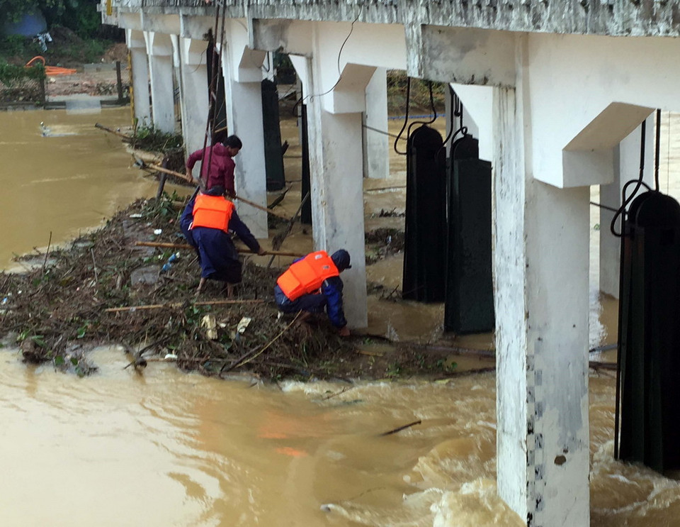 Lực lượng chức năng dọn rác khơi thông dòng chảy, bảo vệ cho cầu Ga (Huế). (Ảnh: Quốc Việt/TTXVN)