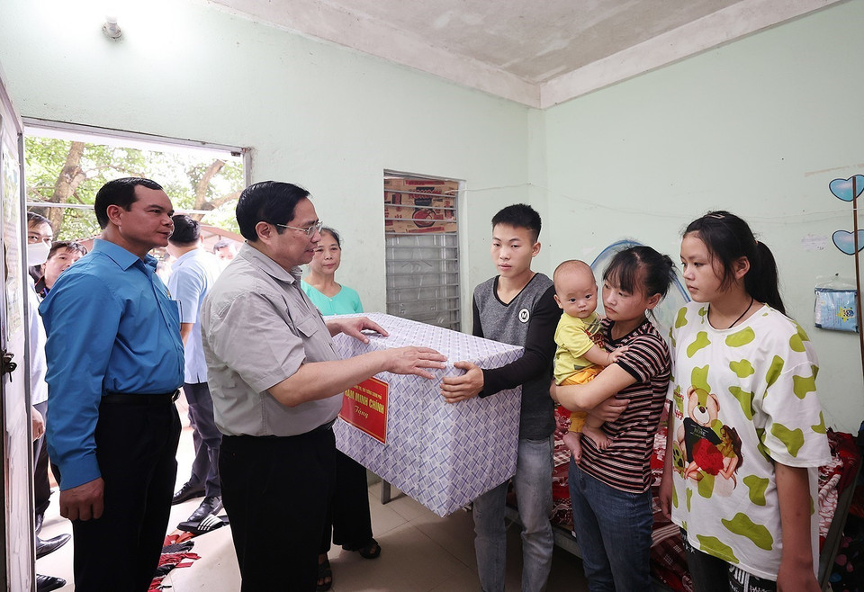 Thủ tướng Phạm Minh Chính thăm, tặng quà cho công nhân đang ở trọ tại thôn An Định, xã Tiền Phong, huyện Yên Dũng.(Ảnh: Dương Giang/TTXVN)