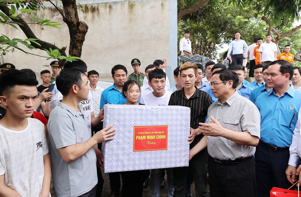 Thủ tướng Phạm Minh Chính thăm, tặng quà cho công nhân đang ở trọ tại thôn An Định, xã Tiền Phong, huyện Yên Dũng.(Ảnh: Dương Giang/TTXVN)