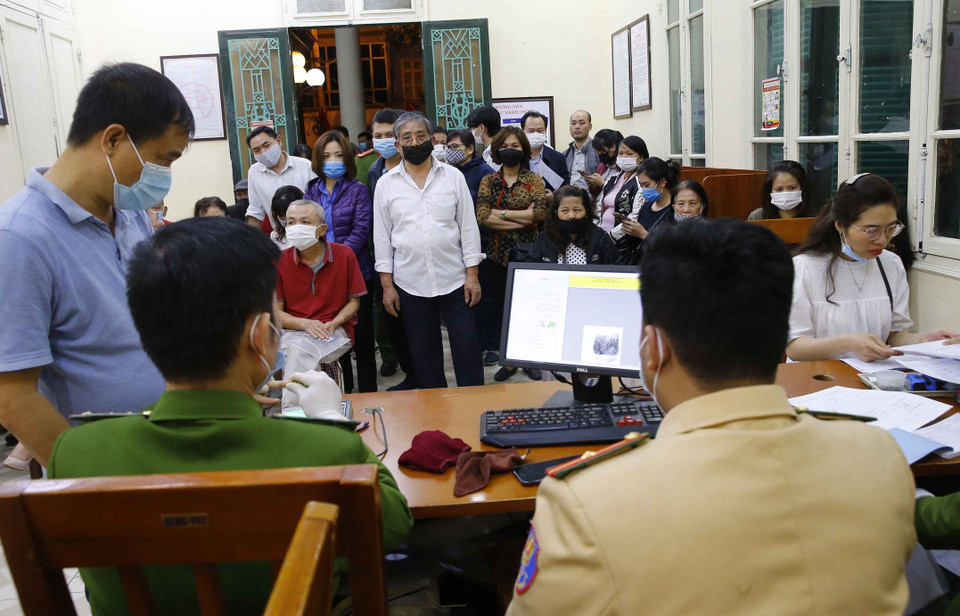 Rất đông người dân chờ đến lượt làm thủ tục tại Trụ sở Công an quận Hai Bà Trưng (số 94 Tô Hiến Thành) (ảnh chụp lúc 21h30 tối 10/3/2021). (Ảnh: Doãn Tấn/TTXVN)