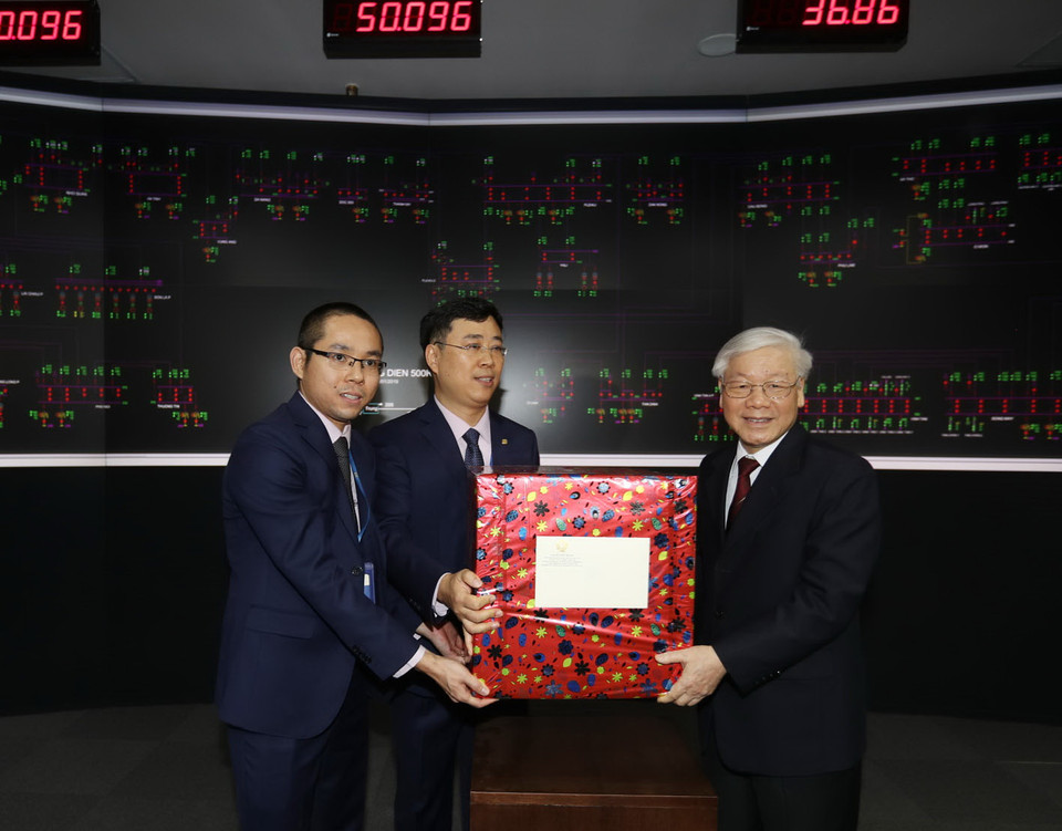 Tổng Bí thư, Chủ tịch nước Nguyễn Phú Trọng tặng quà Tết cho cán bộ, công nhân viên Tập đoàn Điện lực Việt Nam (tối 30 Tết). (Ảnh: Trí Dũng/TTXVN)