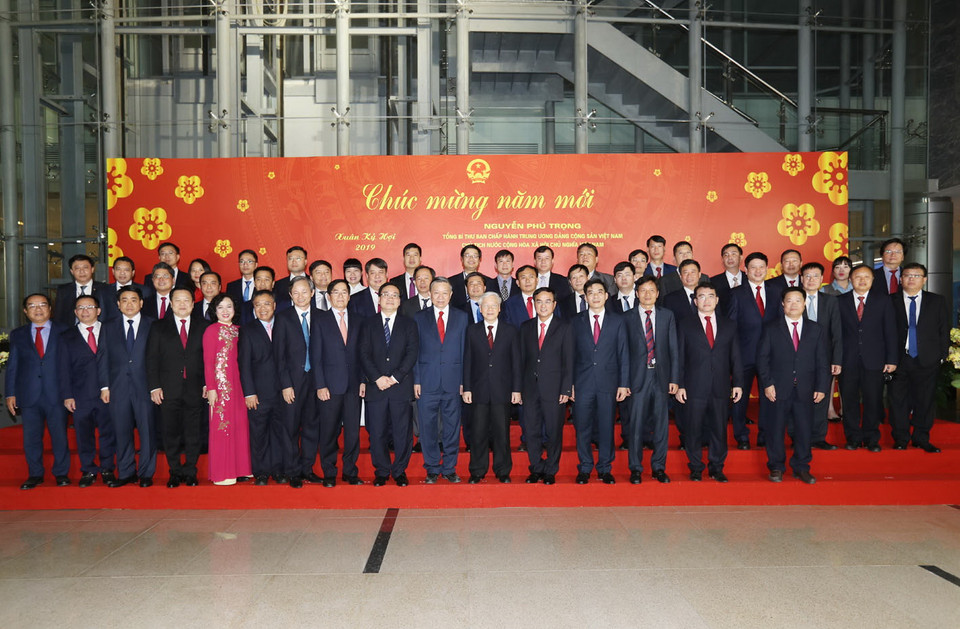 Tổng Bí thư, Chủ tịch nước Nguyễn Phú Trọng và các đại biểu với cán bộ, công nhân viên Tập đoàn Điện lực Việt Nam (tối 30 Tết). (Ảnh: Trí Dũng/TTXVN)