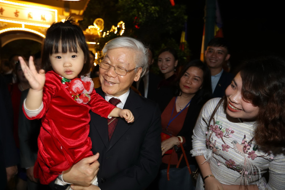 Tổng Bí thư, Chủ tịch nước Nguyễn Phú Trọng chúc Tết, tặng quà nhân dân đang vui Xuân, đón Tết quanh khu vực Hồ Tây đêm Giao thừa. (Ảnh: Trí Dũng/TTXVN)