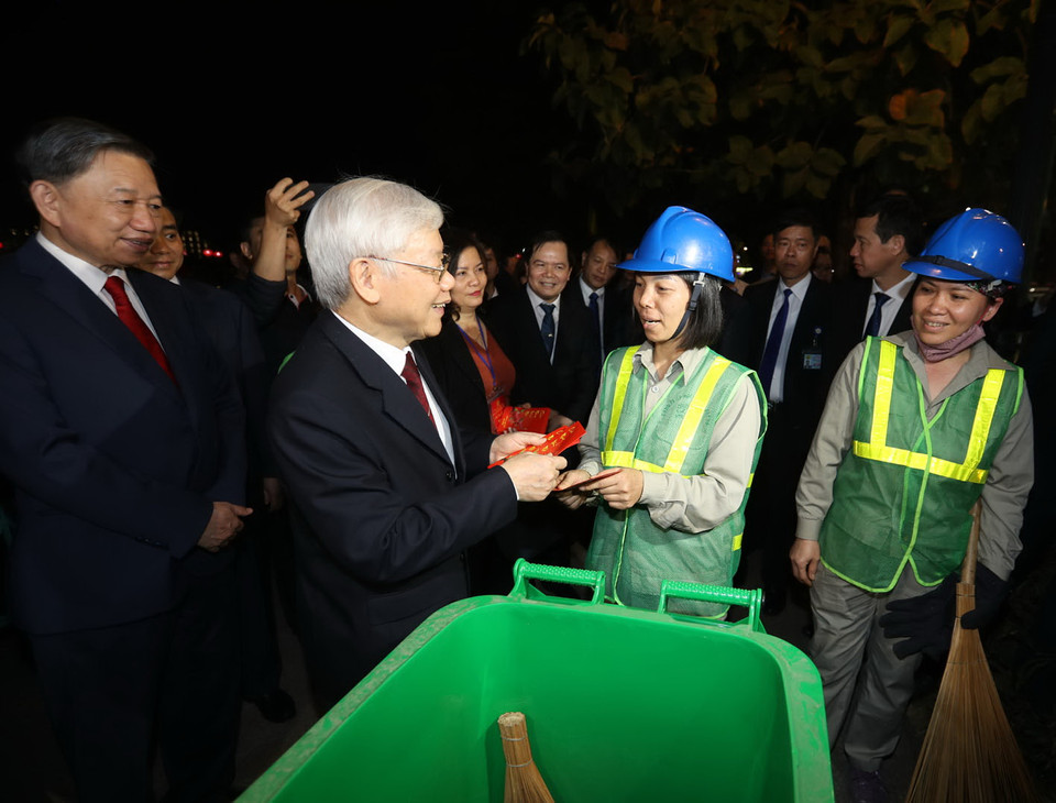 Tổng Bí thư, Chủ tịch nước Nguyễn Phú Trọng thăm hỏi, tặng quà và chúc Tết công nhân môi trường đang làm việc trong đêm Giao thừa tại Hà Nội. (Ảnh: Trí Dũng/TTXVN)