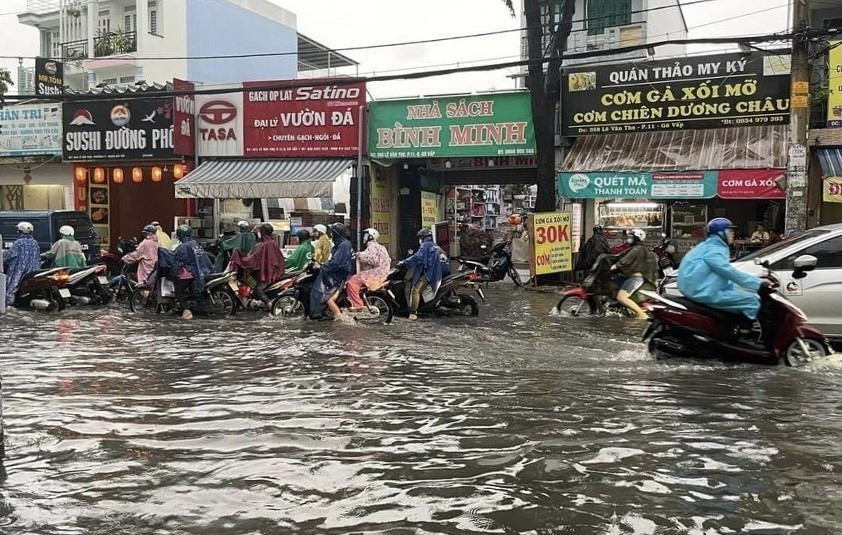Nước ngập gần nửa bánh xe trên đường Lê Văn Thọ, quận Gò Vấp. (Ảnh: Hồng Giang/TTXVN)
