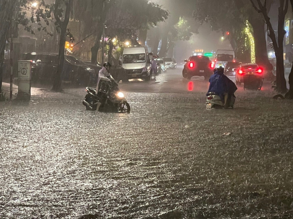 Nhiều phương tiện xe máy loay hoay trong nước ngập đoạn ngã tư Lý Thường Kiệt - Phan Bội Châu, quận Hoàn Kiếm. (Ảnh: An Đăng/TTXVN)