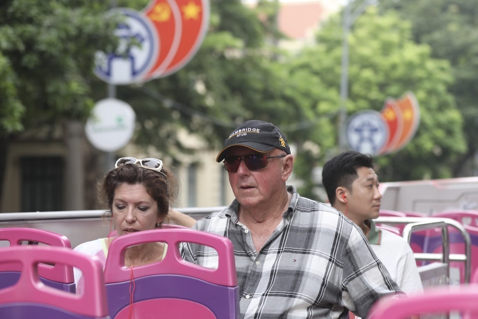 Du khách quốc tế trải nghiệm du lịch xe buýt 2 tầng tham quan Hà Nội. (Ảnh: Minh Quyết/TTXVN)