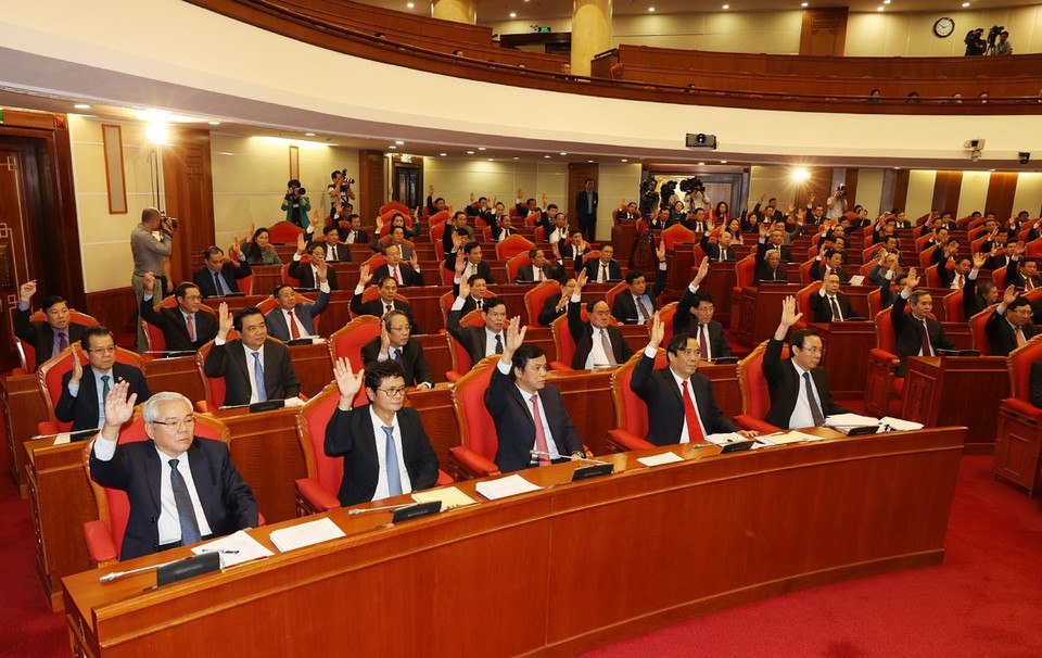 Các đồng chí lãnh đạo Đảng, Nhà nước và các đại biểu biểu quyết thông qua Nghị quyết Hội nghị Trung ương lần thứ 13. (Ảnh: Trí Dũng/TTXVN)