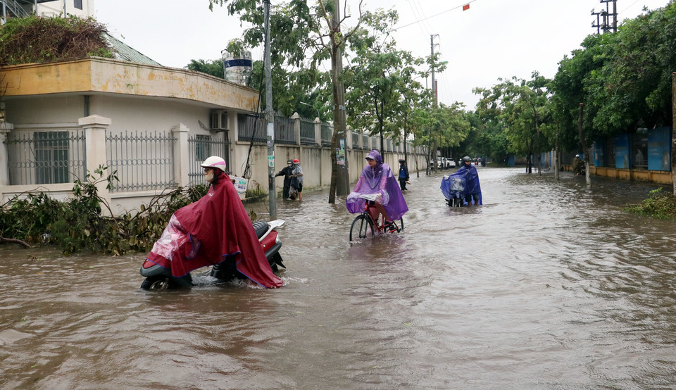 Người dân di chuyển khó khăn qua đường Thích Thế Long, thành phố Nam Định. (Ảnh: Nguyễn Lành/TTXVN)