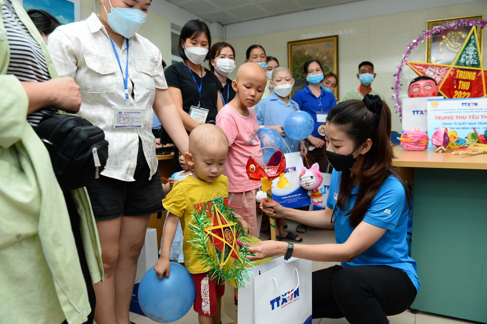 Các đoàn viên TTXVN trao quà cho các bệnh nhi.(Ảnh: Minh Đức/TTXVN)