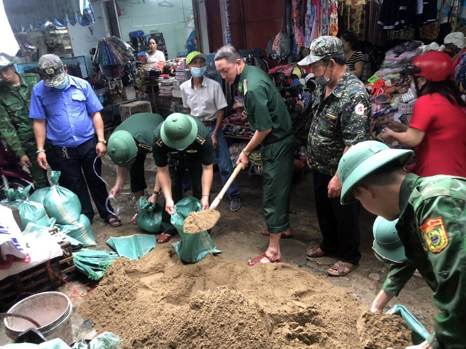 Bộ đội Biên phòng Đà Nẵng giúp dân vận chuyển các bao cát về để chèn mái tôn nhằm ứng phó với bão số 4.(Ảnh: Trần Lê Lâm/TTXVN)