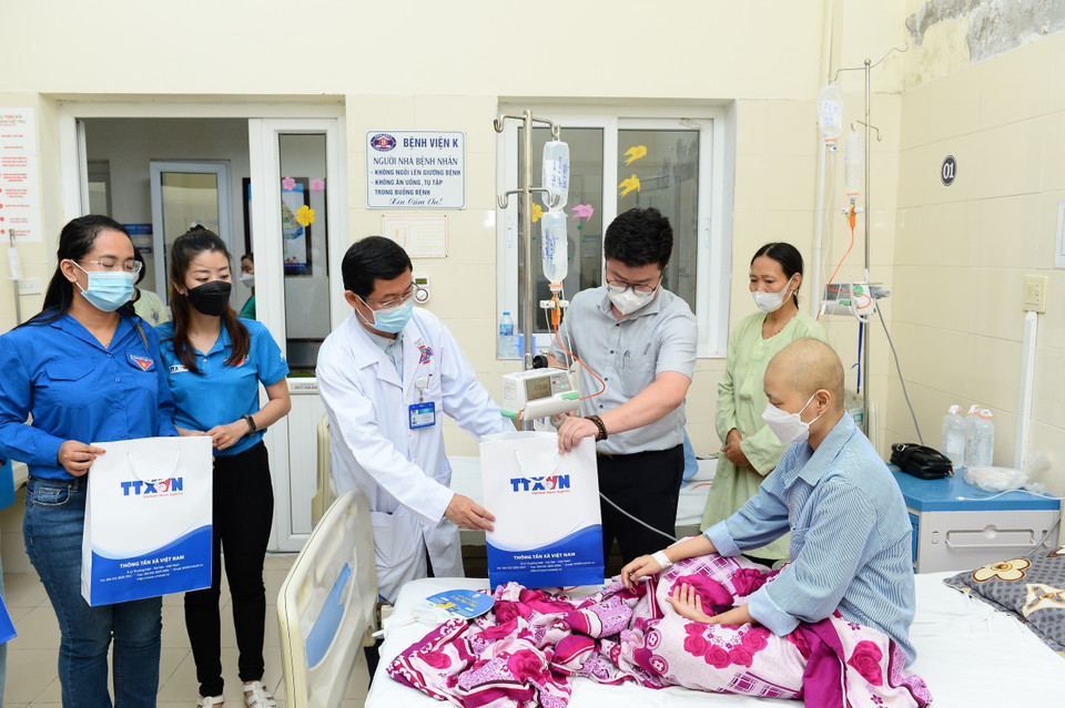 Đại diện Bệnh viện K cùng Đoàn viên Bộ Y tế trao quà cho các bệnh nhi.(Ảnh: Minh Đức/TTXVN)