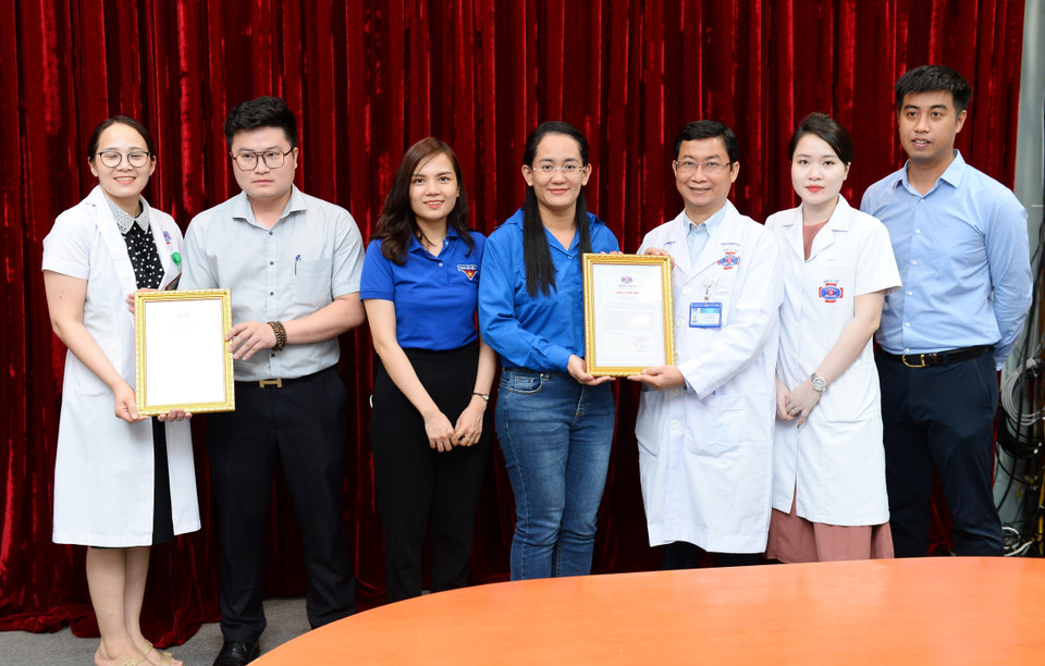 TS. BS. Lê Thanh Đức - phụ trách cơ sở Phan Chu Trinh - Trưởng khoa Nội 5 trao thư cảm ơn cho đoàn thanh niên TTXVN. (Ảnh: Minh Đức/TTXVN)