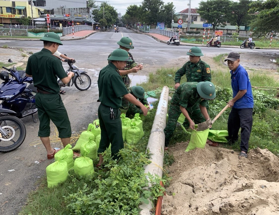 Bộ đội Biên phòng Đà Nẵng giúp dân vận chuyển các bao cát về để chèn mái tôn nhằm ứng phó với bão số 4. (Ảnh: TTXVN phát)