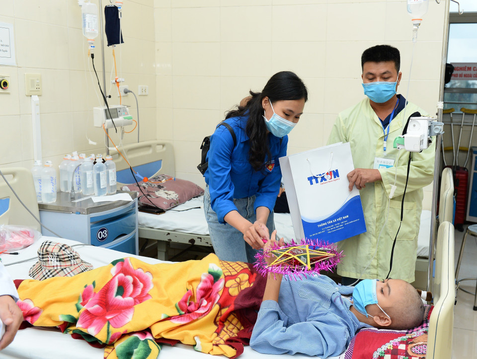 Các đoàn viên TTXVN trao quà cho các bệnh nhi.(Ảnh: Minh Đức/TTXVN)