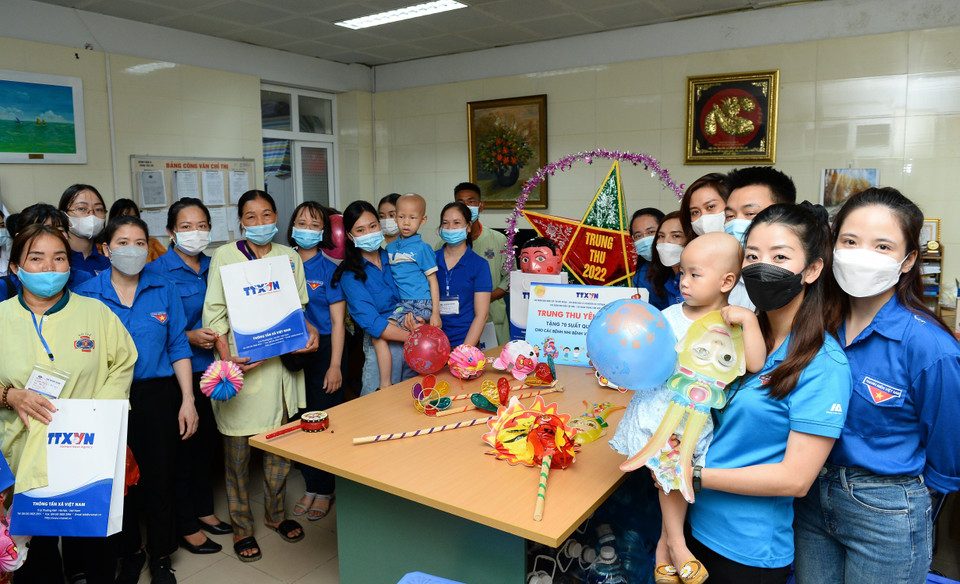 Đoàn thanh niên TTXVN trao bảng tượng trưng 70 suất quà và hơn 300 đầu sách cho Khoa Nhi - Bệnh viện K (cơ sở 3). (Ảnh: Minh Đức/TTXVN)