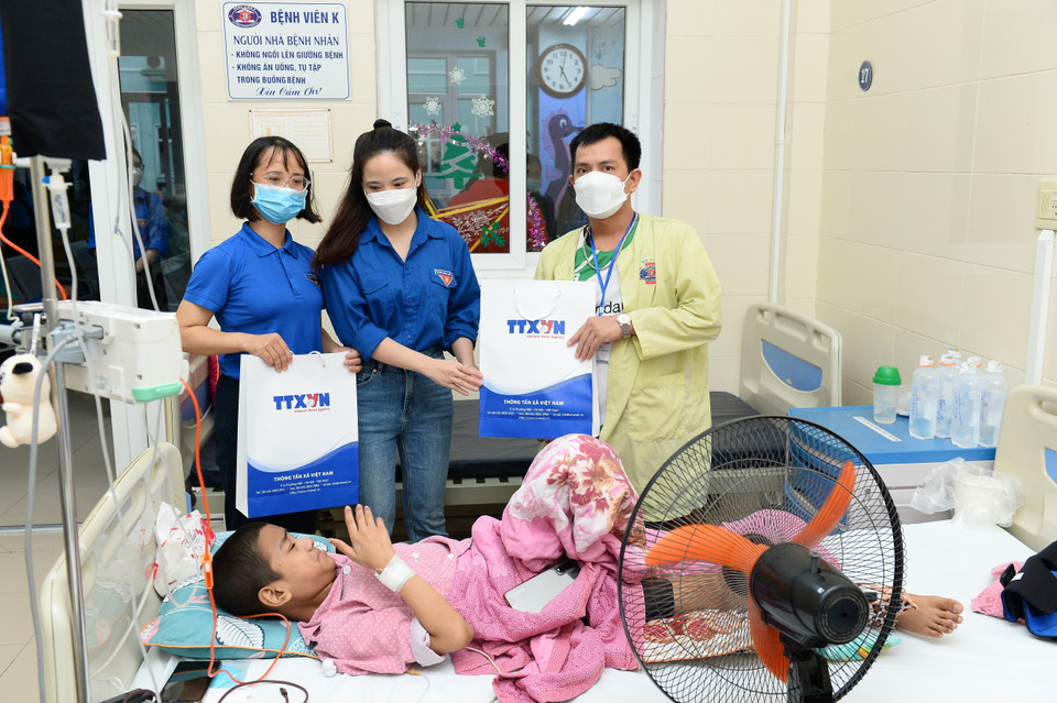 Các đoàn viên TTXVN trao tặng tủ sách yêu thương cho Khoa Nhi - Bệnh viện K (Tân Triều). (Ảnh: Minh Đức/TTXVN)