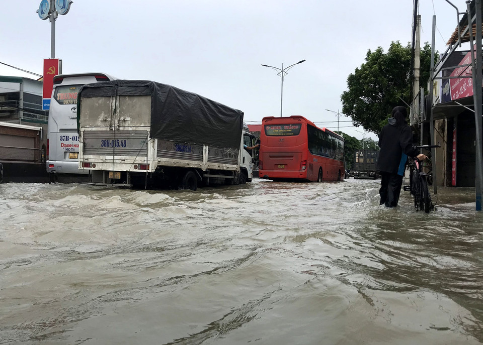 Do lưu thông qua đoạn đường ngập khó khăn nên đã xảy ra tình trạng ùn ứ kéo dài gần 2km trên Quốc lộ 1A (đoạn qua trị trấn Cầu Giát, huyện Quỳnh Lưu). (Ảnh: Văn Tý/TTXVN)